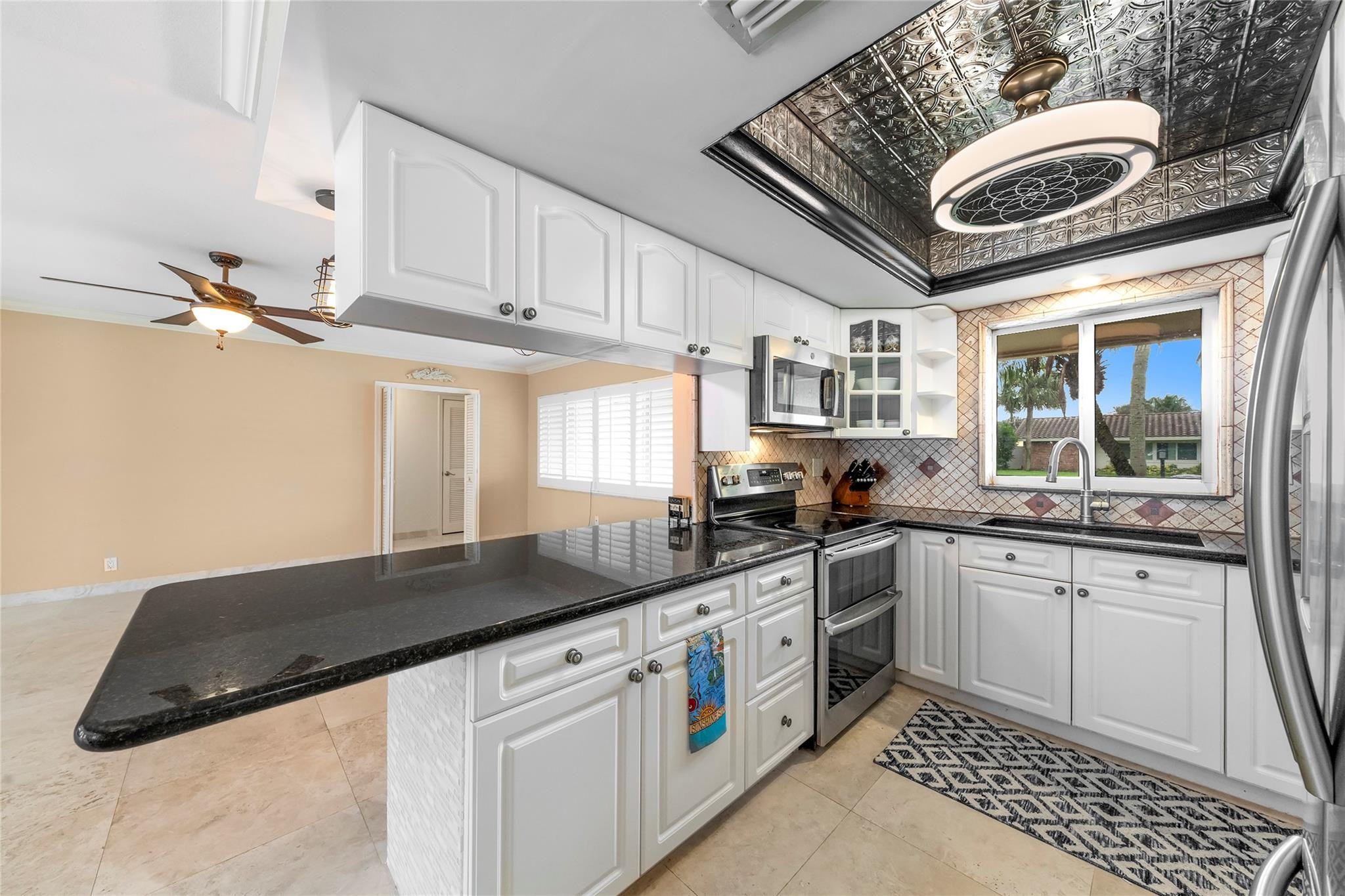 2061 North Conference Drive Boca Raton, FL 33486 - Photo 10 of 27 a kitchen with granite countertop a sink and cabinets
