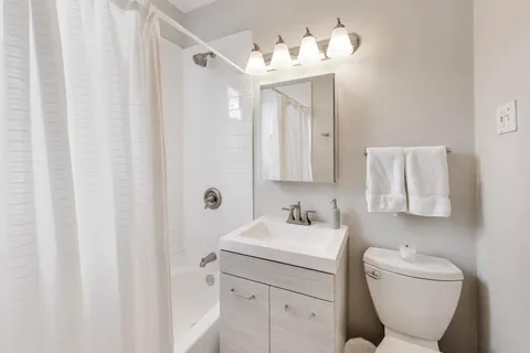 a bathroom with a toilet sink and mirror