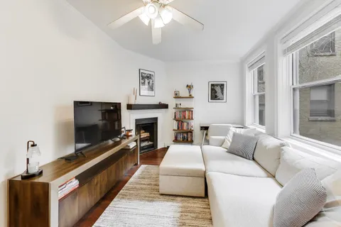 a living room with furniture a flat screen tv and a fireplace