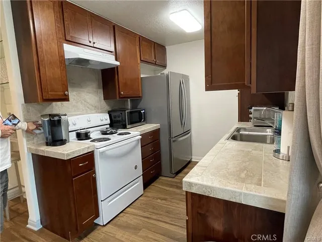 a kitchen with a sink a refrigerator and cabinets
