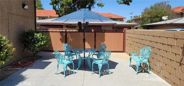 a view of a patio with table and chairs under an umbrella