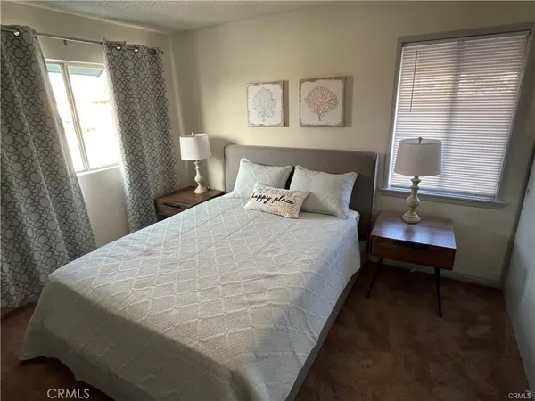 a large bed sitting in a bedroom next to a window