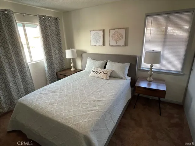a large bed sitting in a bedroom next to a window