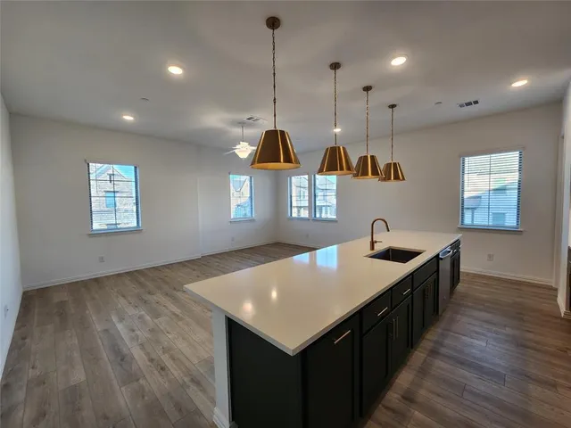 a kitchen with stainless steel appliances granite countertop a sink a microwave a refrigerator and a stove