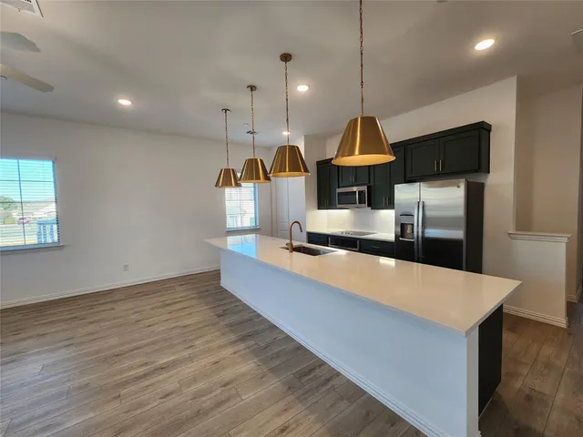 a kitchen with stainless steel appliances a refrigerator a stove top oven a sink and dishwasher