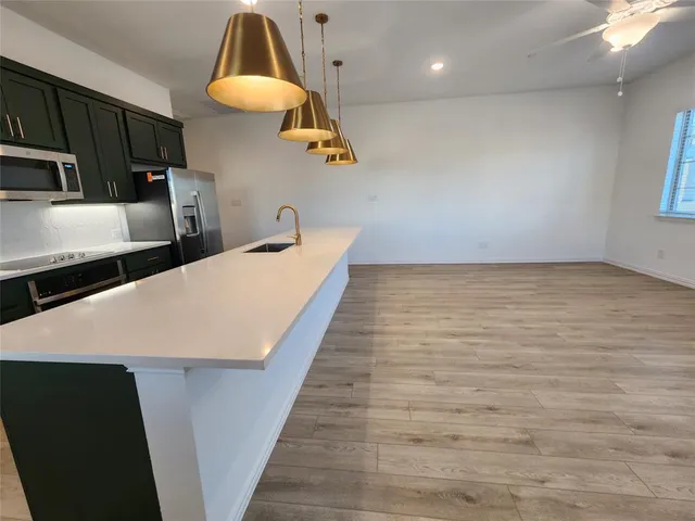 a kitchen with stainless steel appliances a stove a refrigerator a sink and dishwasher