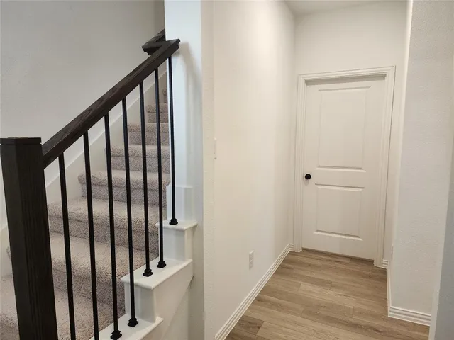 a view of a hallway with wooden floor and staircase