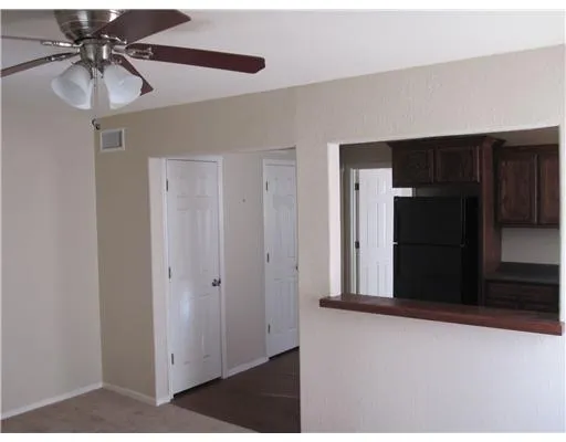 a view of a hallway with a chandelier fan and wooden floor
