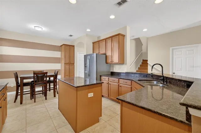 a kitchen with stainless steel appliances granite countertop a sink a stove and a refrigerator