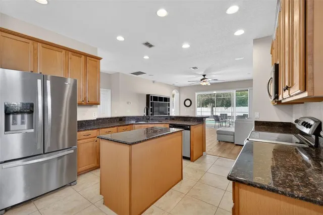 a kitchen with stainless steel appliances granite countertop a sink stove and refrigerator