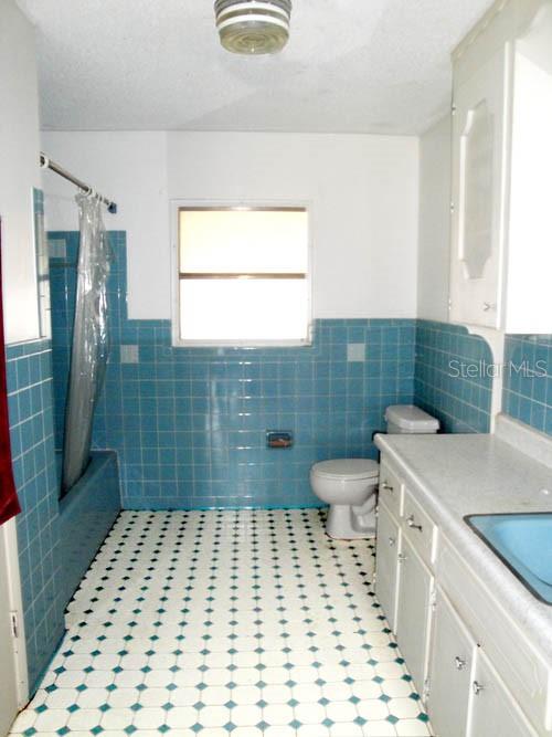 3130 Northeast 7th Lane Ocala, FL 34470 - Photo 5 of 9 a bathroom with a sink a toilet a window and vanity