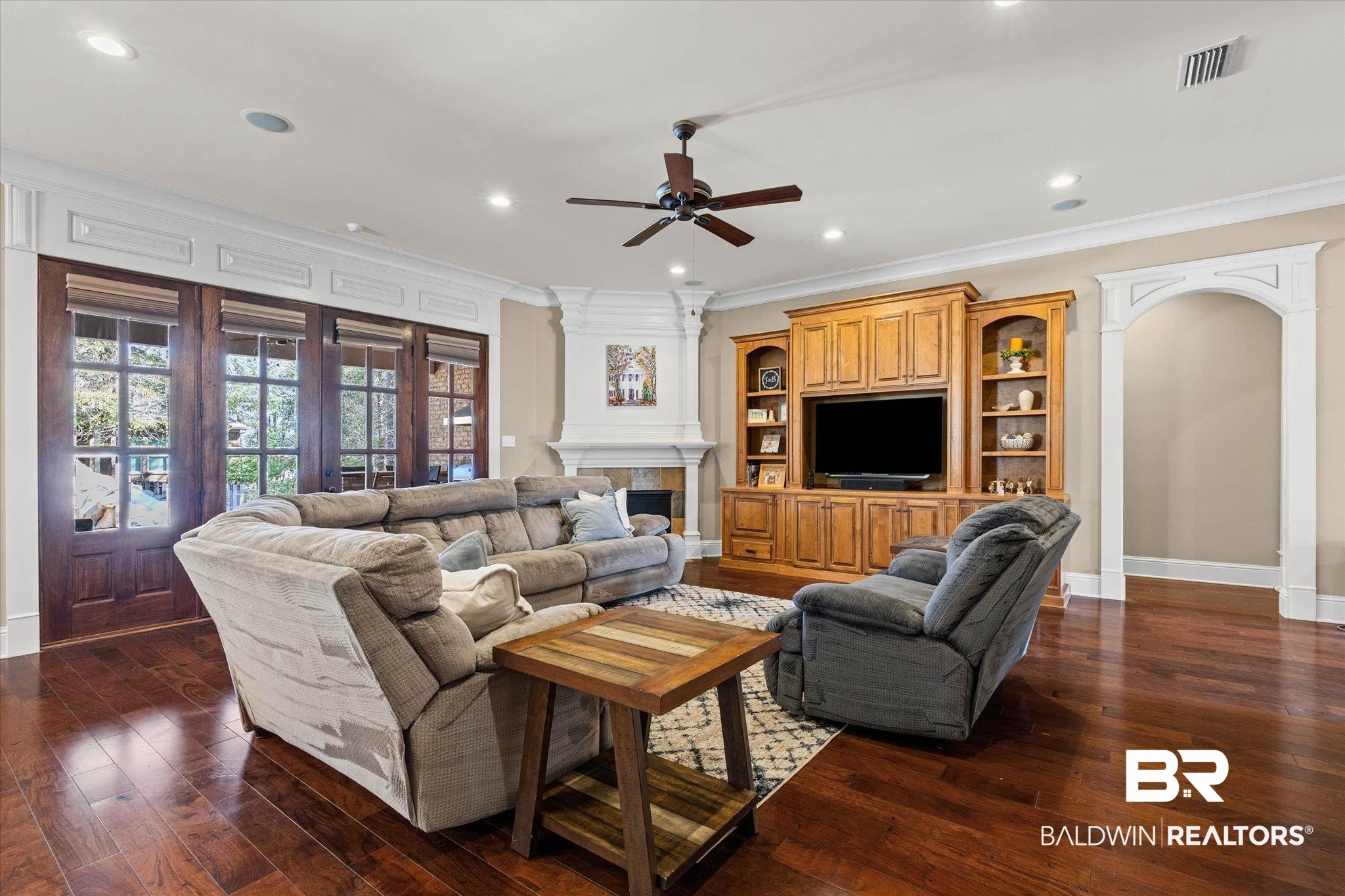 7676 Rockstone Lane Mobile, AL 36695 - Photo 9 of 47 Living area with a tiled fireplace, crown molding, a ceiling fan, dark wood-type flooring, and recessed lighting
