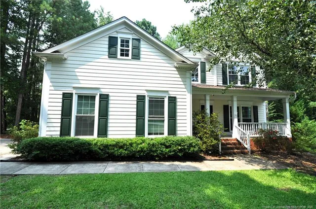 a front view of a house with a yard and porch