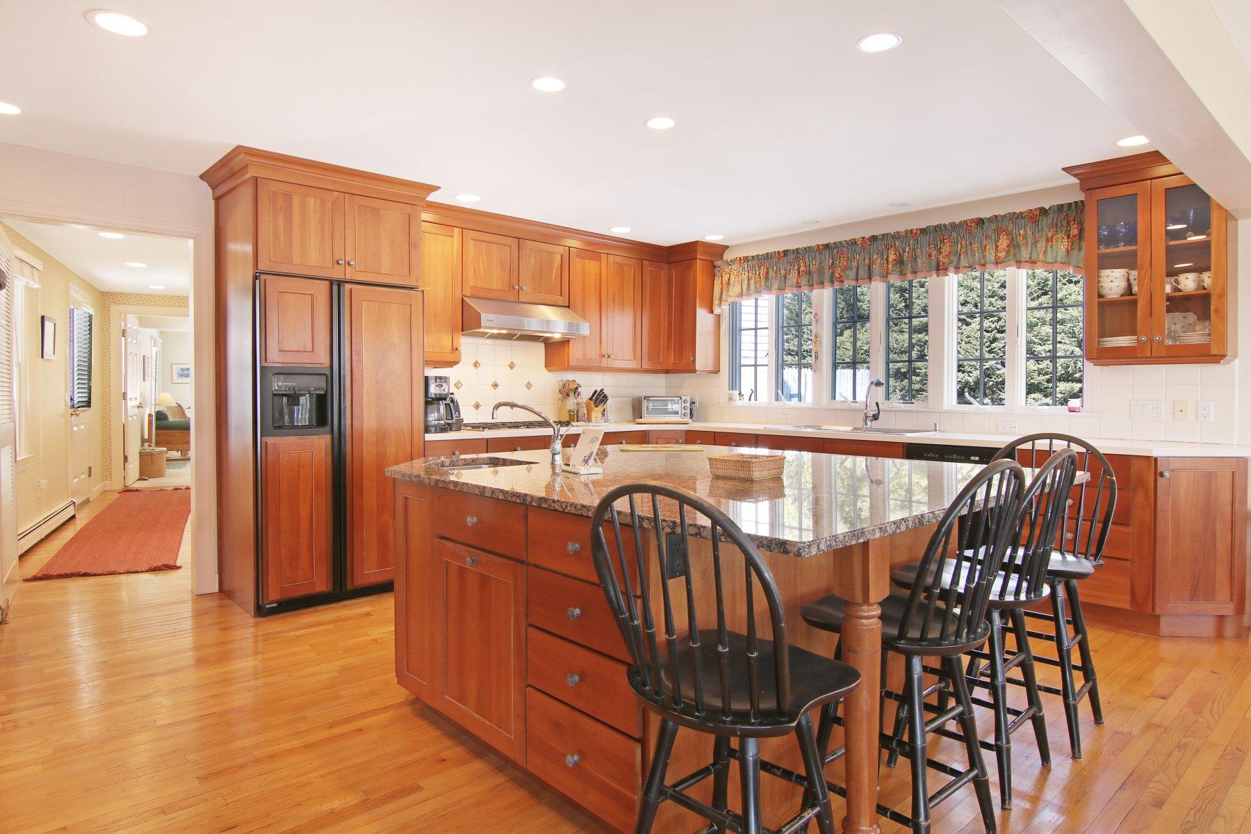 16 Thayer Lane Orleans, MA 02653 - Photo 16 of 35 a kitchen with stainless steel appliances granite countertop a table chairs and a refrigerator