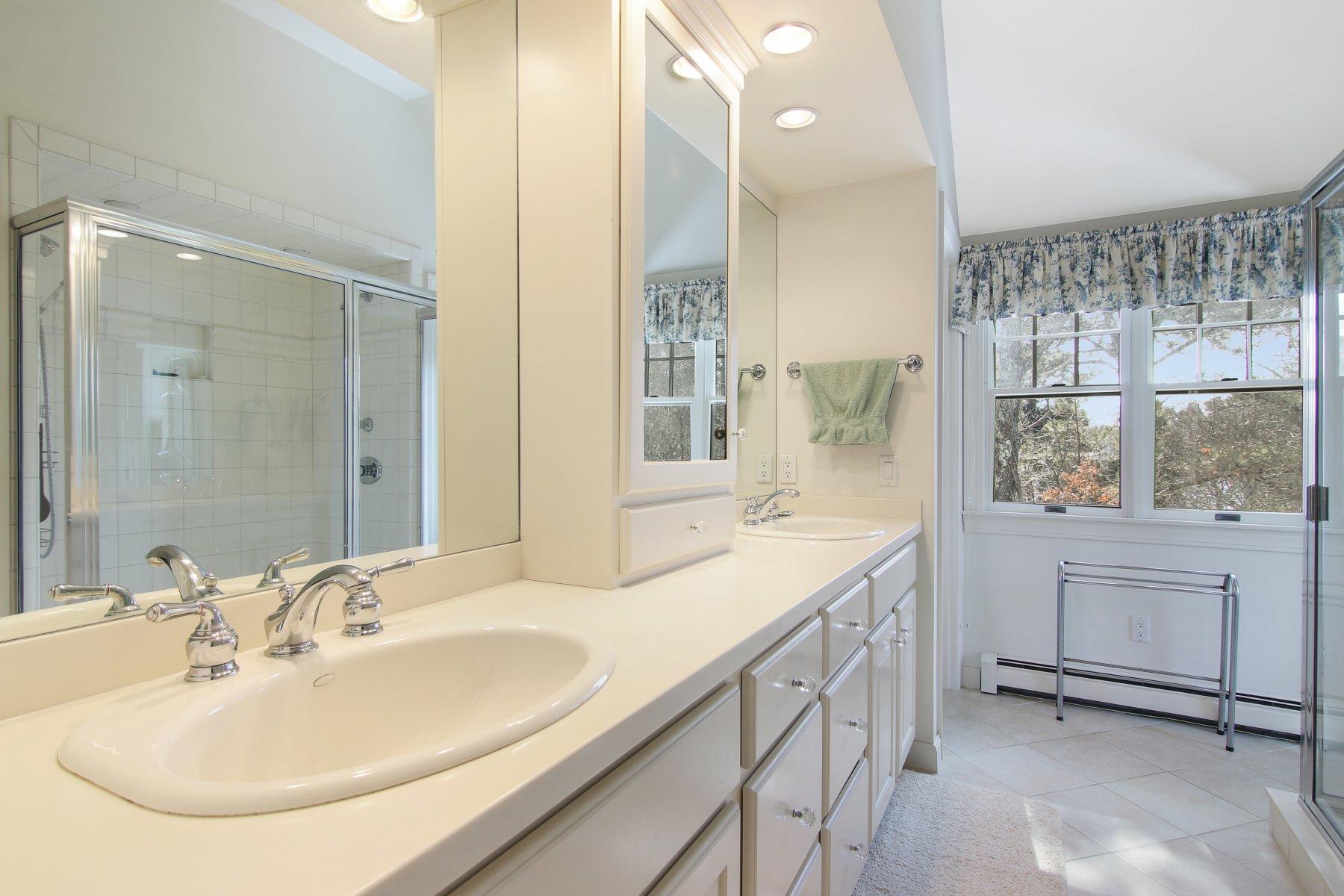 16 Thayer Lane Orleans, MA 02653 - Photo 20 of 35 a bathroom with a double vanity sink a mirror and a bathtub