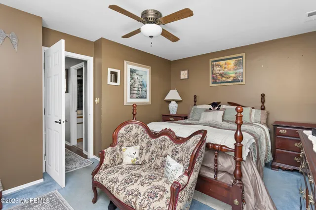 a bedroom with a bed and a large mirror on the dresser