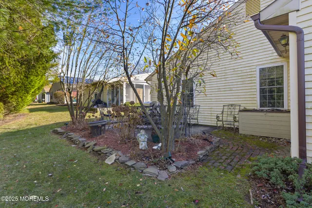 a backyard of a house with large trees and plants