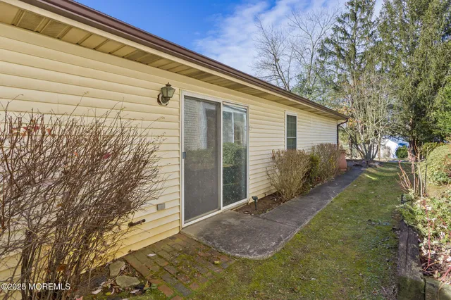 a view of a white house with a yard and potted plants