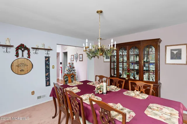 a view of a dining room with furniture and chandelier