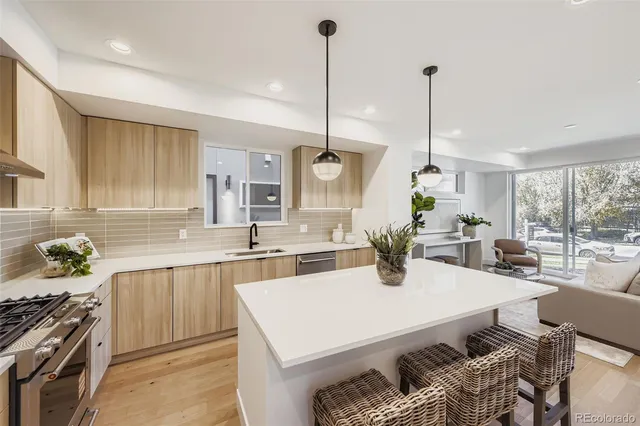 a kitchen with stainless steel appliances kitchen island granite countertop a stove a sink and a white cabinets