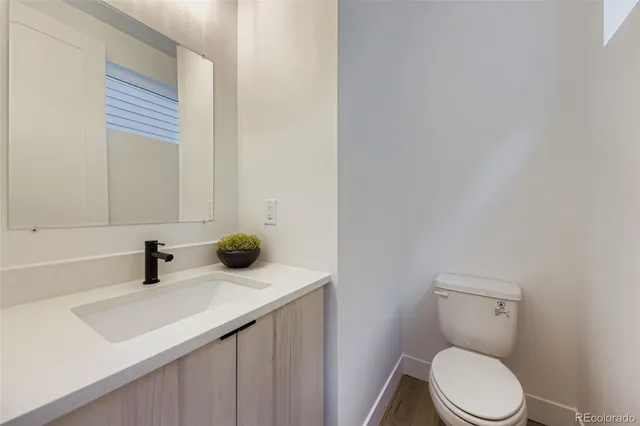 a bathroom with a toilet a sink and mirror