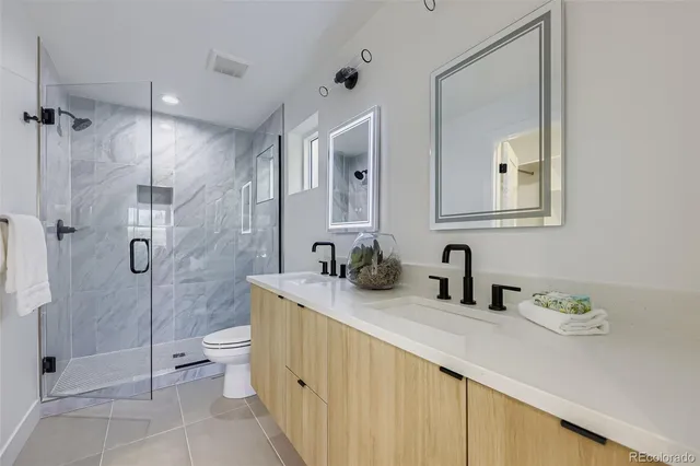 a bathroom with a double vanity sink mirror and shower