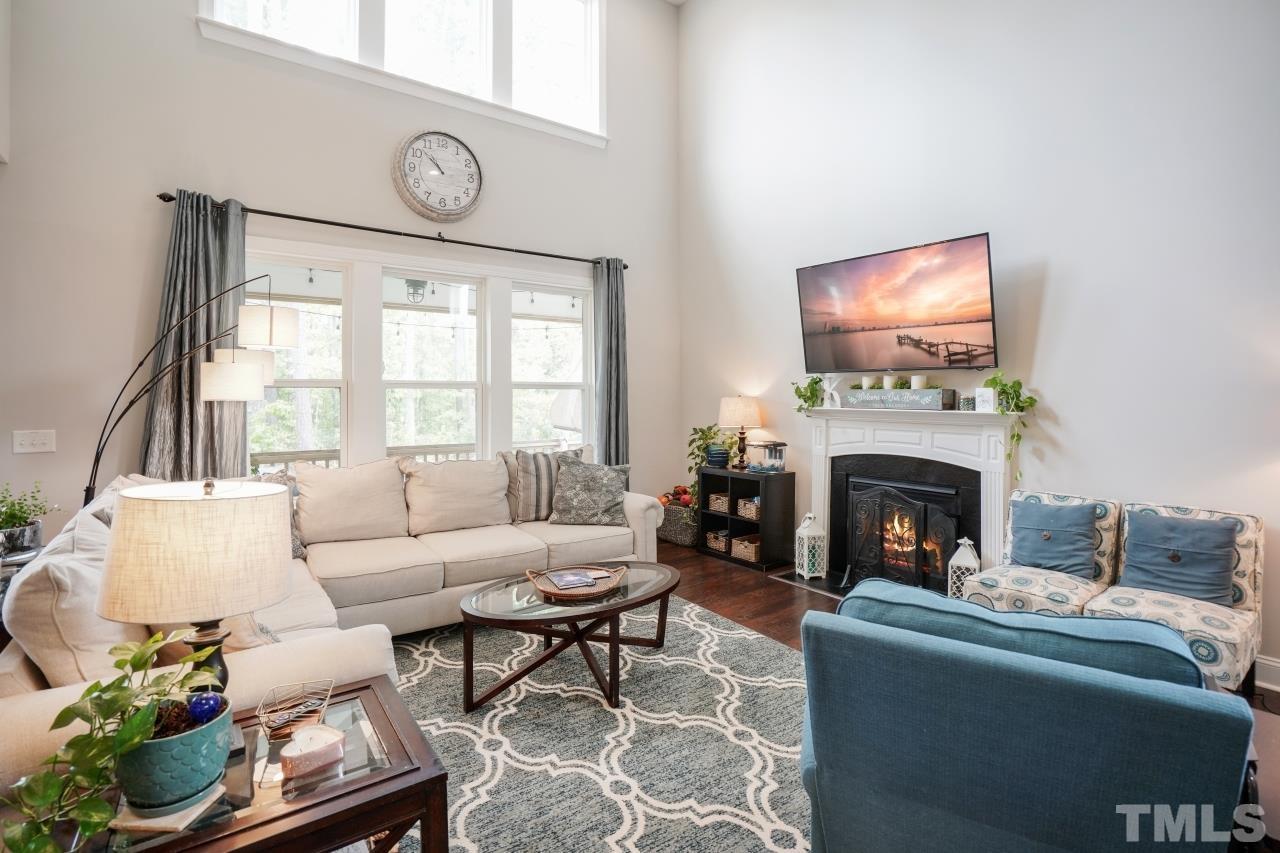 3373 Willow Green Drive Apex, NC 27502 - Photo 11 of 42 a living room with furniture a fireplace and a flat screen tv