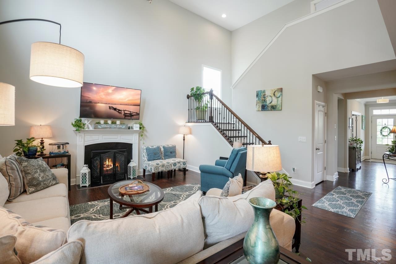 3373 Willow Green Drive Apex, NC 27502 - Photo 13 of 42 a living room with furniture a fireplace and a flat screen tv