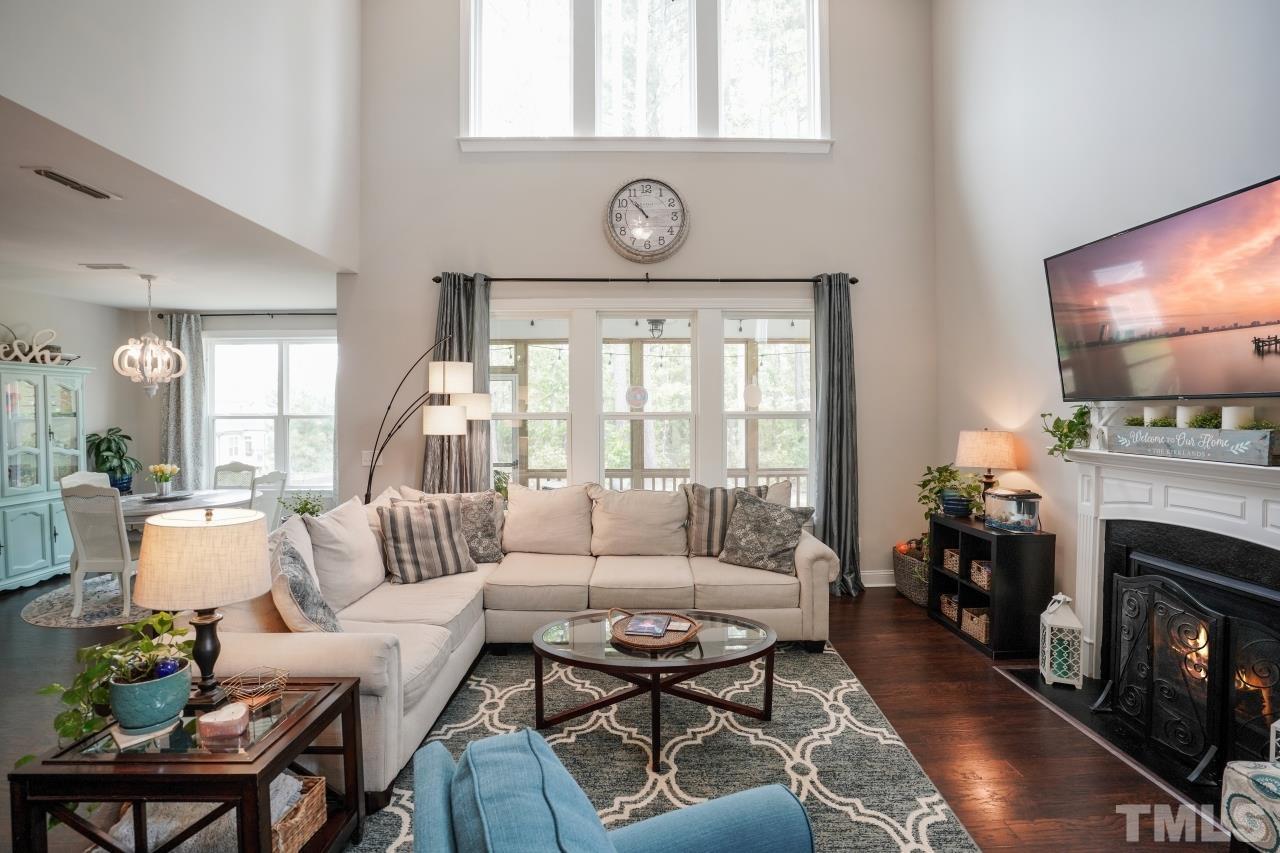 3373 Willow Green Drive Apex, NC 27502 - Photo 14 of 42 a living room with furniture a fireplace a flat screen tv and a large window
