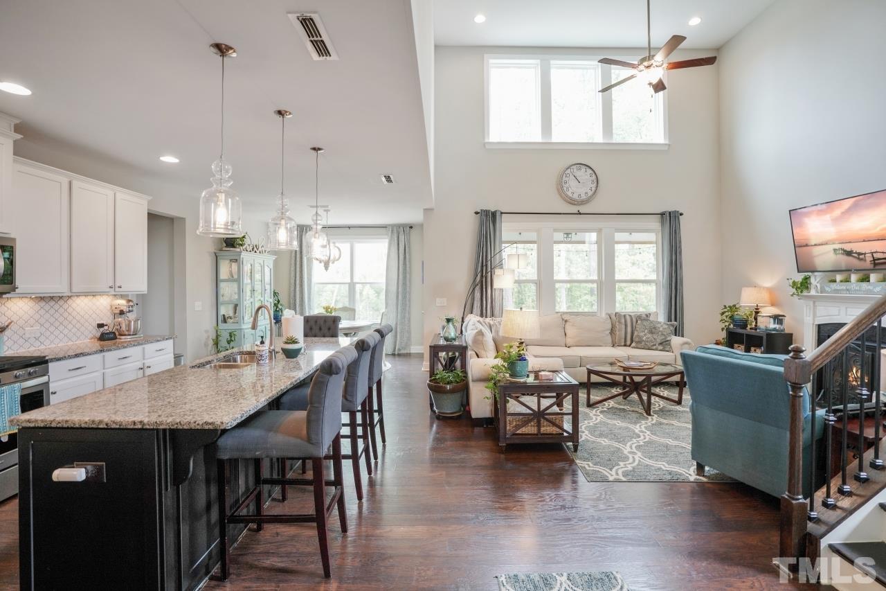 3373 Willow Green Drive Apex, NC 27502 - Photo 15 of 42 a dining room with wooden floor a chandelier a wooden table and chairs