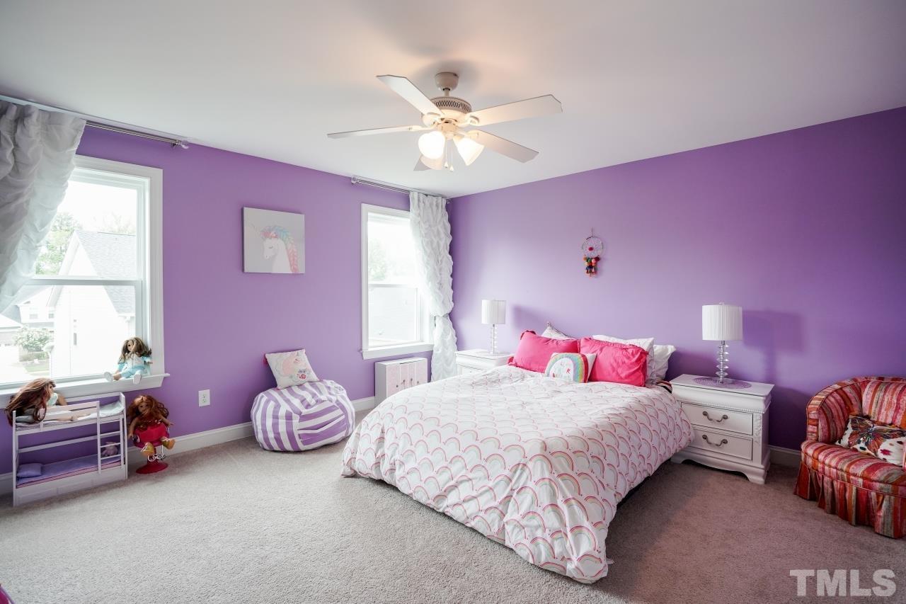 3373 Willow Green Drive Apex, NC 27502 - Photo 31 of 42 a bedroom with a bed and a chandelier