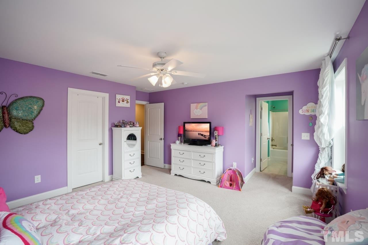 3373 Willow Green Drive Apex, NC 27502 - Photo 32 of 42 a bedroom with a bed and chandelier