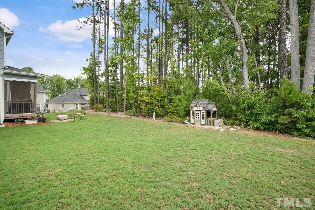 3373 Willow Green Drive Apex, NC 27502 - Photo 37 of 42 a tall white house with a yard and trees