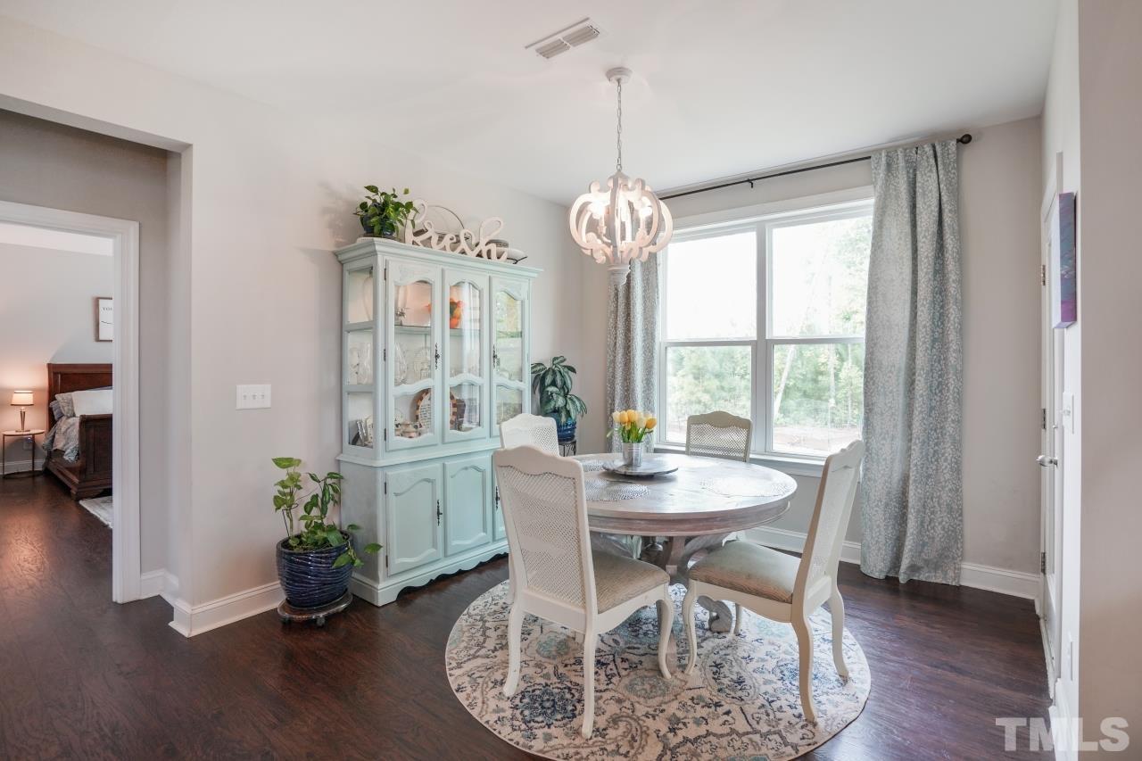 3373 Willow Green Drive Apex, NC 27502 - Photo 9 of 42 a dining room with furniture a chandelier and wooden floor