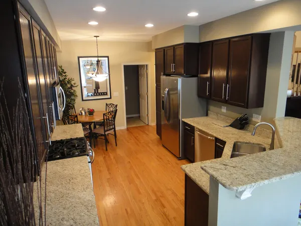 a kitchen with stainless steel appliances granite countertop a refrigerator and a sink