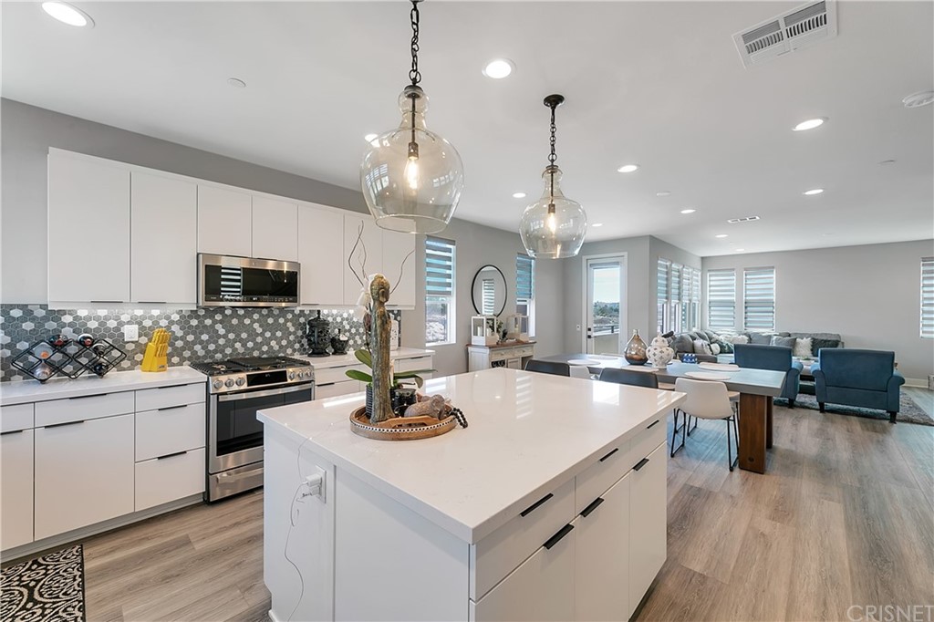 1051 Canal Street Oxnard, CA 93035 - Photo 12 of 37 a kitchen with a stove a microwave oven a stove and white cabinets with wooden floor