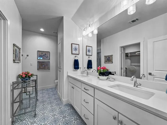 a spacious bathroom with double vanity sinks a mirror and a shower