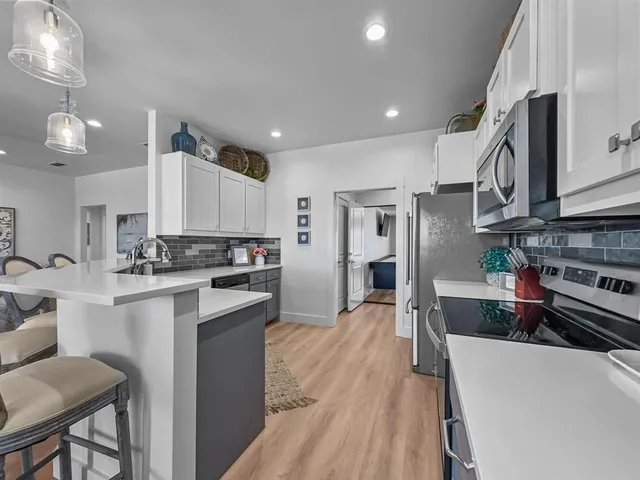 a large kitchen with stainless steel appliances lots of counter space and a sink