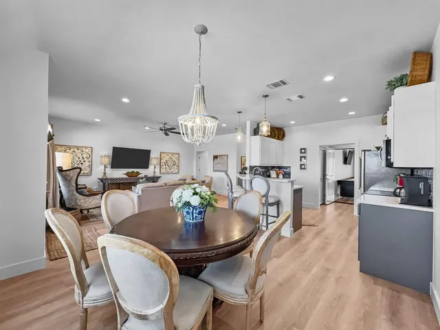 a view of a dining room and livingroom with furniture wooden floor a chandelier