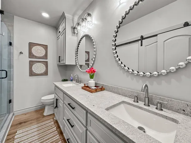 a bathroom with a double vanity sink mirror and toilet