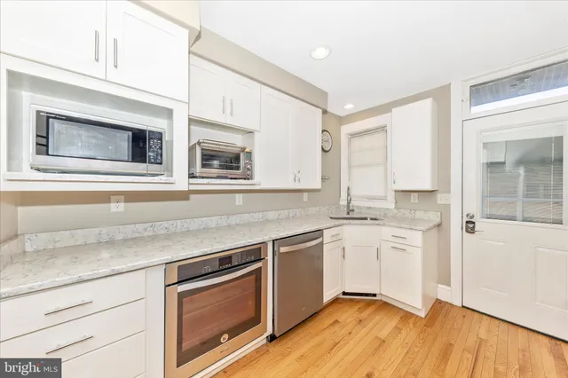 a kitchen with stainless steel appliances granite countertop cabinets and wooden floor