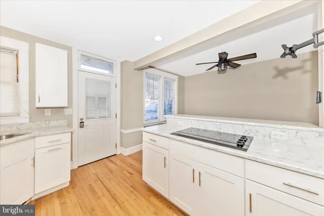 a spacious bathroom with a granite countertop sink a mirror and shower