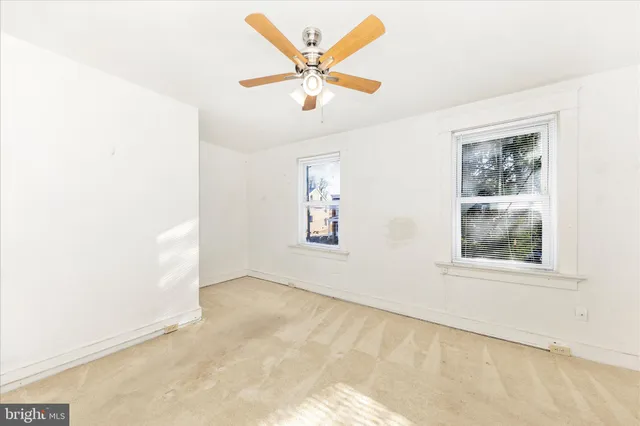 an empty room with closet and fan
