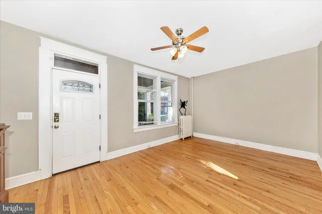 a view of an empty room and window with wooden floor