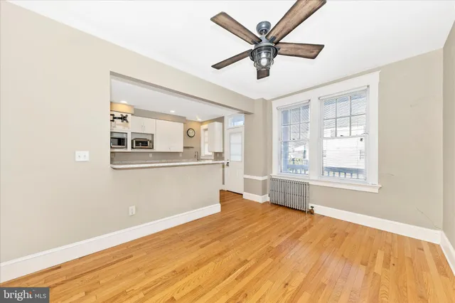 a view of a big room with wooden floor and windows