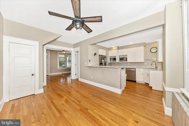 a view of a kitchen with wooden floor and a sink