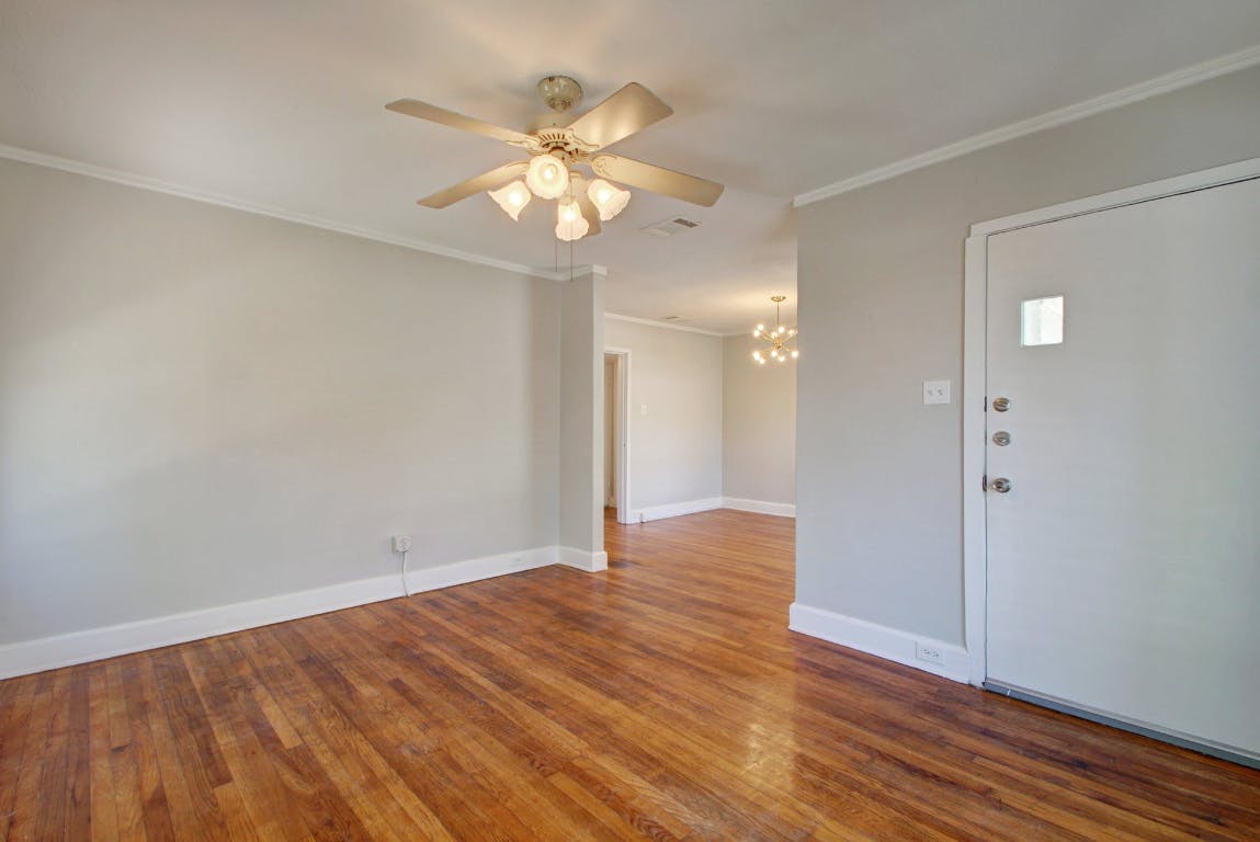 1 East 53rd Street Austin, TX 78751 - Photo 4 of 13 Unfurnished room featuring ornamental molding, hardwood / wood-style floors, a chandelier, and ceiling fan
