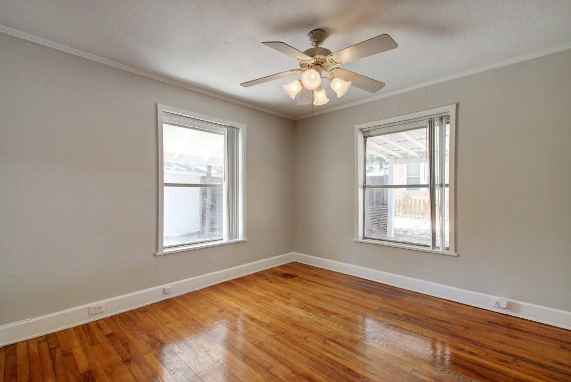 1 East 53rd Street Austin, TX 78751 - Photo 6 of 13 Empty room with ornamental molding, light wood-type flooring, plenty of natural light, and a ceiling fan