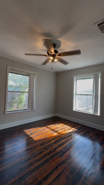 1 East 53rd Street Austin, TX 78751 - Photo 9 of 13 Unfurnished room featuring healthy amount of natural light, ornamental molding, dark wood-style floors, and a ceiling fan