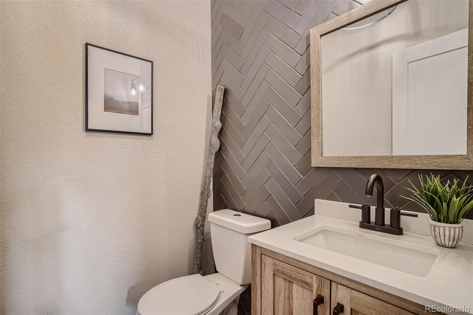 3806 Simms Court Wheat Ridge, CO 80033 - Photo 18 of 30 a bathroom with a toilet sink and mirror